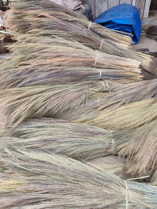 Hand-tied grass broom heads ready for finishing